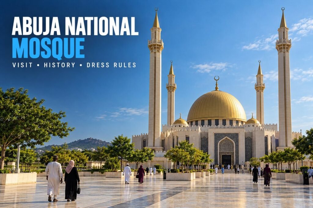 The golden dome and four minarets of the Abuja National Mosque against a clear blue sky with its courtyard in the foreground